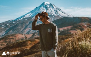 Trendy man standing in front of a mountain